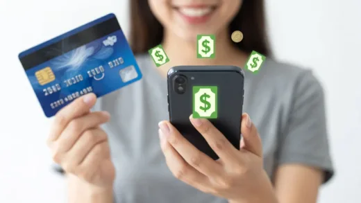 A person happily holding a smartphone with money symbols appearing, representing easy money retrieval. The background shows a credit card and a pile of coins.