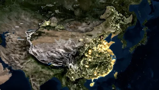 Satellite image of North Korea at night, showing specific areas with increased light compared to previous years, symbolizing economic activity and growth. The image should convey a sense of a surprising development amidst darkness.