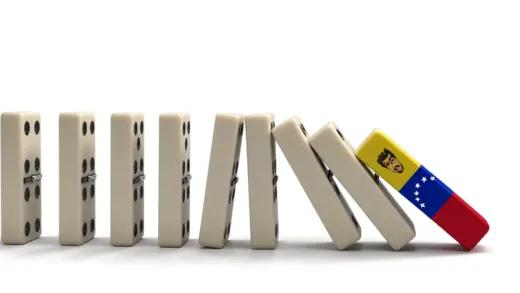 A series of large dominoes falling, with the first one representing Venezuela's Maduro regime, and the second one impacting an island nation reminiscent of Cuba. The overall scene conveys a sense of dramatic collapse and interconnectedness, with shadows of societal disruption.