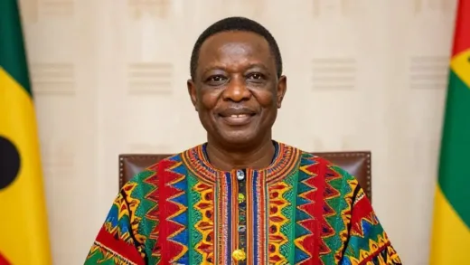 A dignified man in traditional Ghanaian Kente fabric, smiling, with a subtle Korean traditional pattern in the background, symbolizing his dual heritage. The setting is formal, like an ambassador's office.