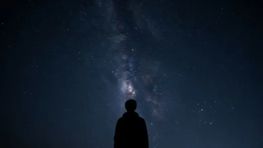 A person gazing at a vast, star-filled night sky, with a sense of wonder and slight apprehension about the endlessness of space. High detail, cosmic.