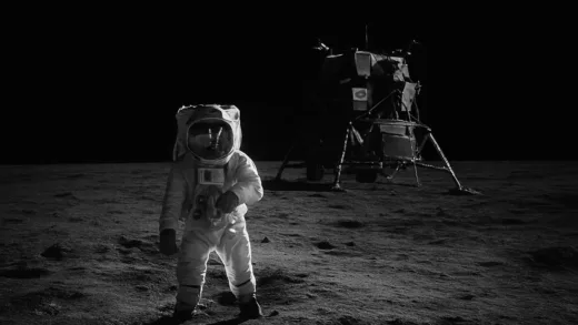 An iconic vintage photograph of an astronaut on the moon with the lunar module, against a completely dark, starless sky. The image should evoke a sense of mystery and historical significance.