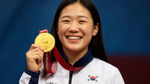 A young, smiling Korean female Paralympian, Kim Yun-ji, holding a gold medal, looking confident and happy, celebrating her victory.