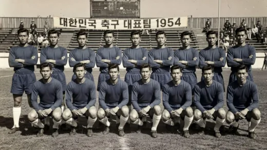 Historical black and white photo of 1954 South Korean football team in blue uniforms, vintage aesthetic, players with old-fashioned haircuts, retro football stadium background, grainy texture