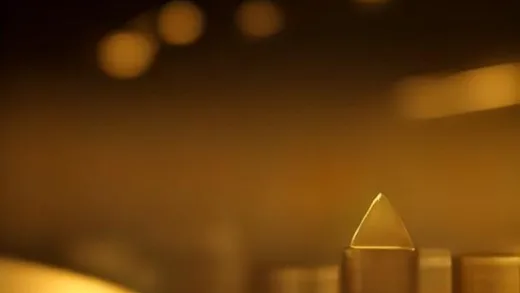A sophisticated, slightly abstract image of a gold Nobel Prize medal floating above a growing stack of investment charts, with a glowing light representing financial wisdom. In the background, a subtle representation of a stable foundation.